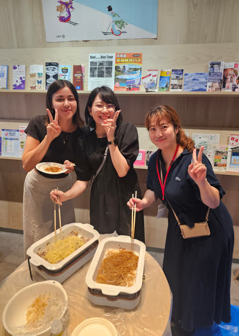Five people prepare food at a table.